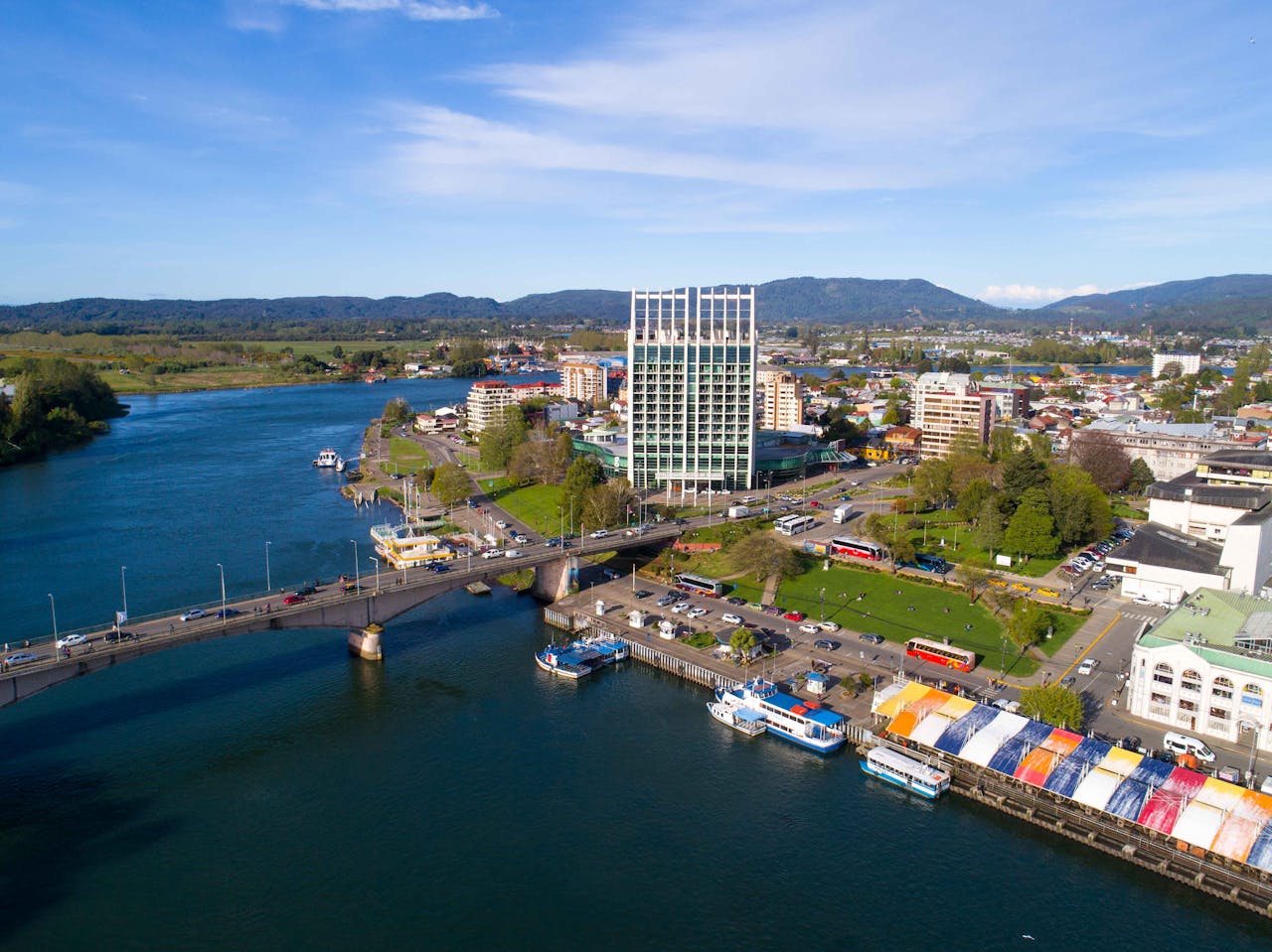 Aerial view of Valdivia, Chile, showcasing the river, bridge, and modern architecture.